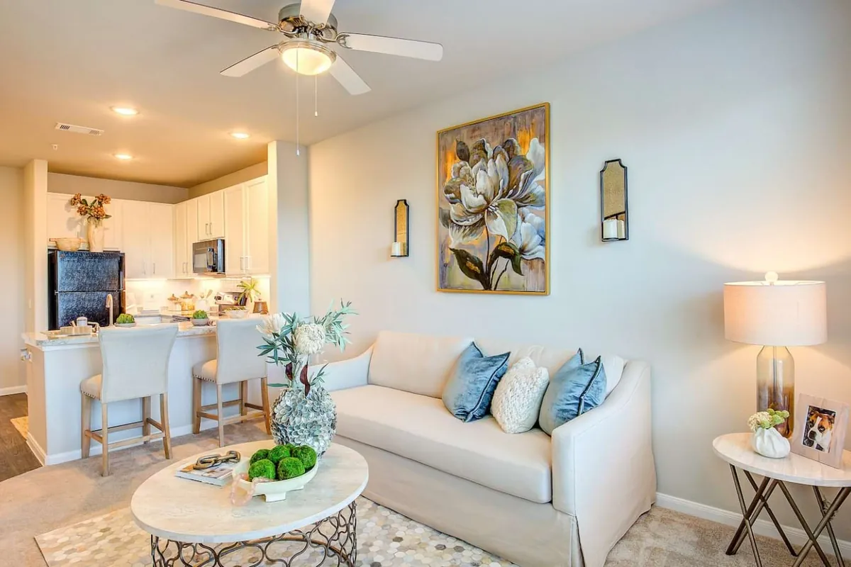 Cole Park in McKinney: living room with a cream sofa, a round coffee table and a ceiling fan, open to a kitchen with an island