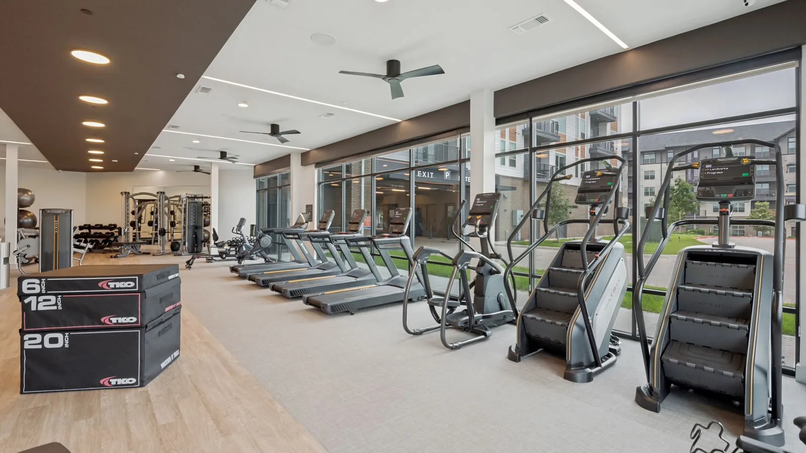 Jefferson Marquee in Lewisville: fitness center with treadmills, stair climbers and plyometric boxes beside a wall of windows