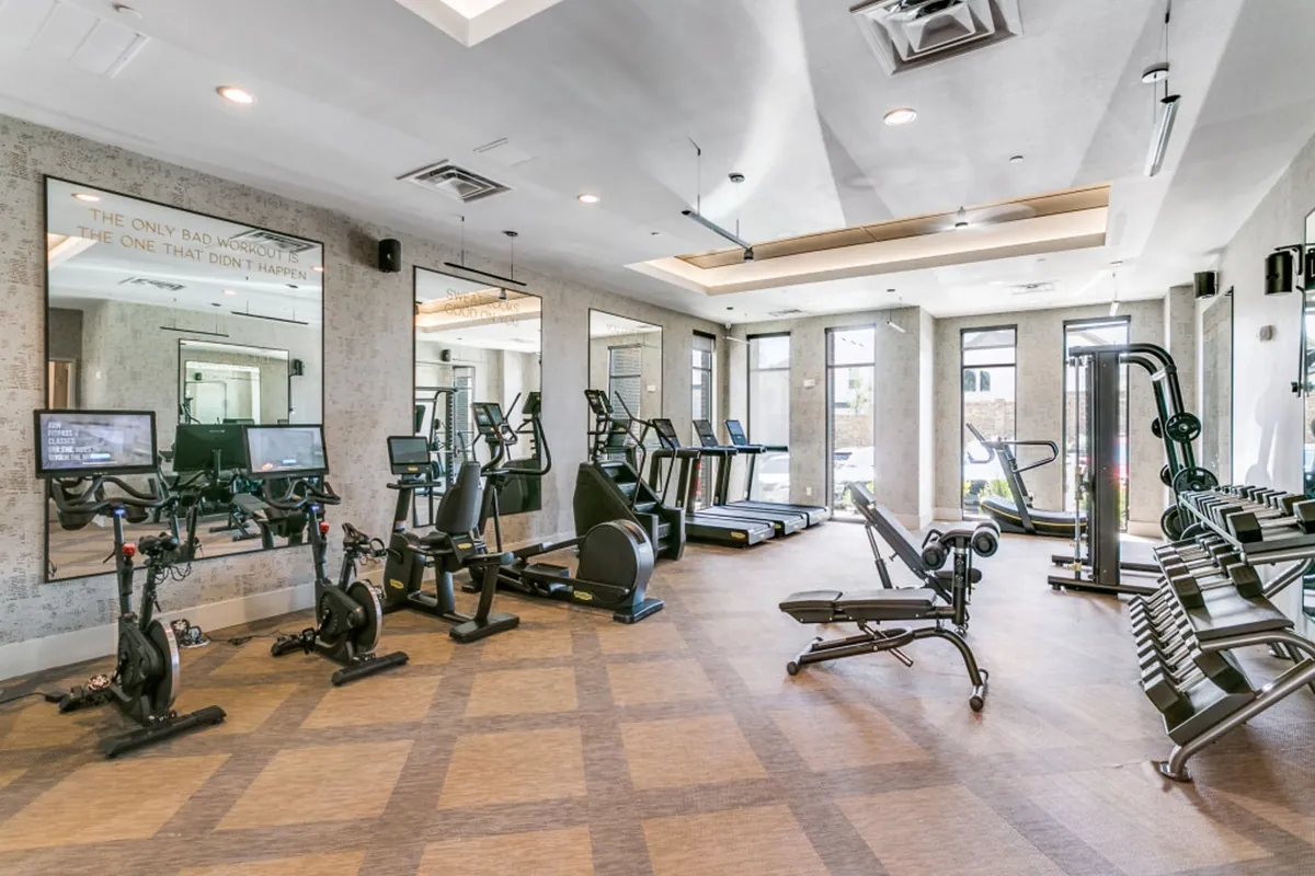 Sagemont in Irving: fitness center with exercise bikes, treadmills, weight benches and a mirrored wall